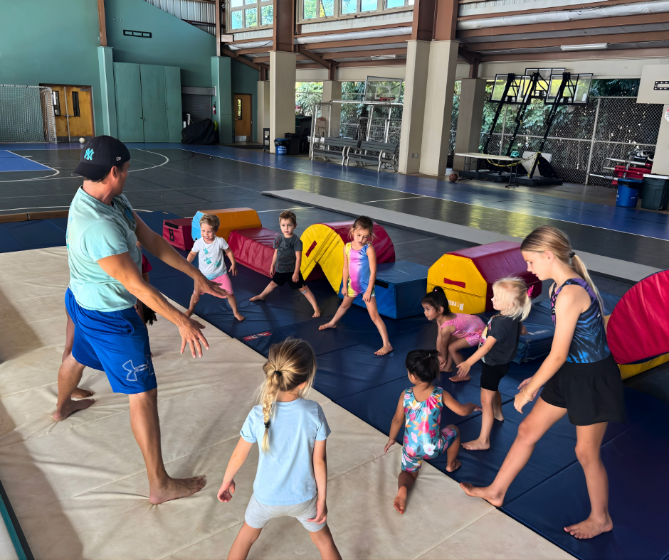 Mobile gymnastics program with coach instructing children